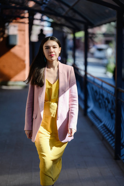 Autumn portrait of beautiful woman in yellow dress and pink blazer. - Photo, image