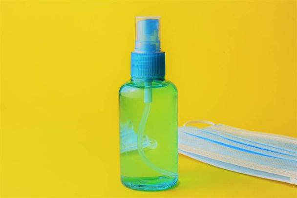 Close up, hygienic measures, hydroalcoholic gel and surgical masks, on a yellow background - Fotografie, Obrázek