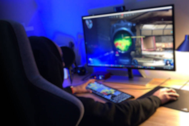 Adolescente PC Gamer jugando tirador en primera persona en la luz tenue - Foto, Imagen
