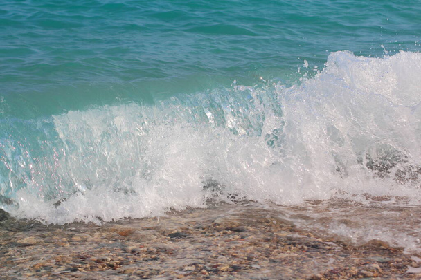 una ola de mar de cresta blanca sube y se estrella en la playa de arena. Ola foto de fondo. - Foto, imagen