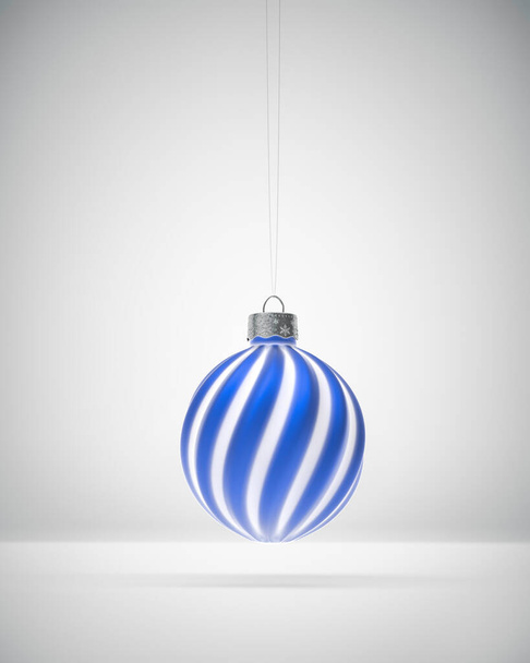 Mattblau-weiß gestreifter Weihnachtsschmuck hängt vor weißem Hintergrund. Diffuses Licht. Weihnachtsdekoration, festliches Ambiente. - Foto, Bild