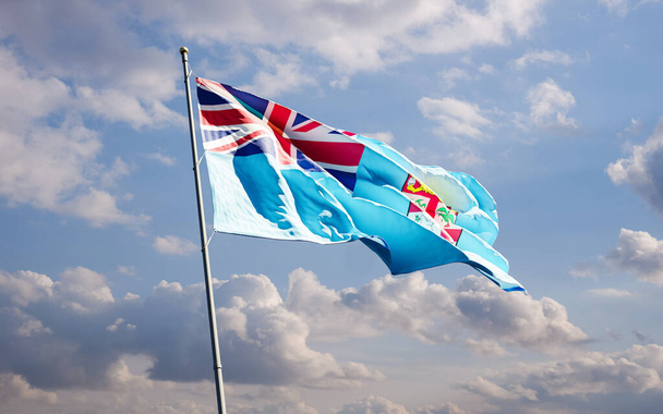 Fiji staat vlag zwaaien in de wind tegen blauwe bewolkte lucht achtergrond lage hoek close-up. Vlag van Fiji Eiland. - Foto, afbeelding