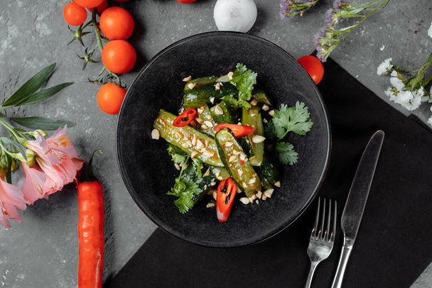 Salad of broken cucumbers with sesame seeds, sugar, red and black pepper, olive oil. - Photo, Image