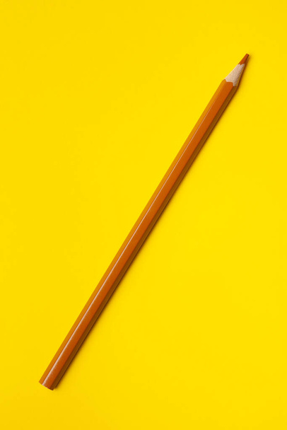 diagonal light brown sharp wooden pencil on a bright yellow background, isolated, copy space, mock up - Foto, immagini