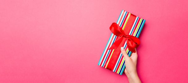 Girl Hands segurando caixa de presente de papel artesanal com como um presente para o Natal ou outro feriado no fundo rosa, vista superior com sppace cópia. - Foto, Imagem