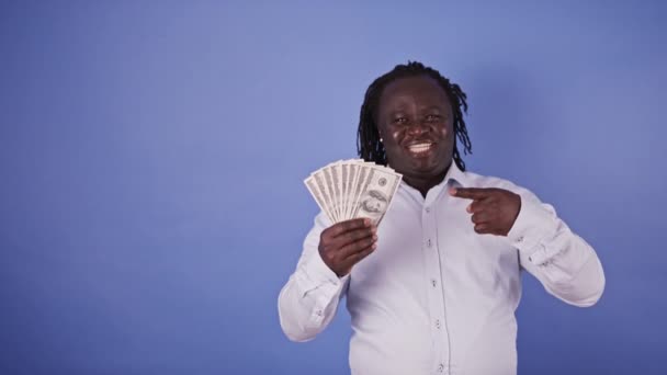 Hombre africano sosteniendo el dinero en su mano y señalándolo con el dedo - Metraje, vídeo