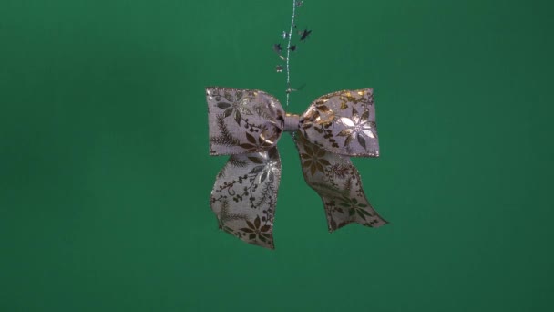 Gold Bow Ribbon With Gold Leaf Design Hanging Off Tinsel. Green Screen, Locked Off - Footage, Video
