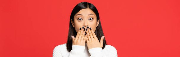 schockierte asiatische Frau bedeckt Mund mit rot isolierten Händen, Banner - Foto, Bild