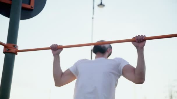 Close up de homem musculoso fazendo pull-ups na barra horizontal. Na área de treino perto de casa - Filmagem, Vídeo