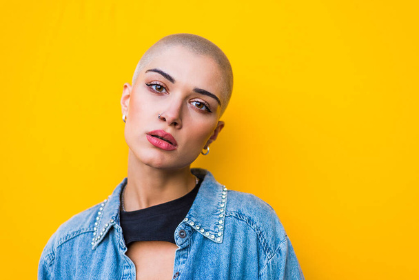 Pretty girl with stylish clothes posing - Beautiful woman with shaved head portrait - 写真・画像
