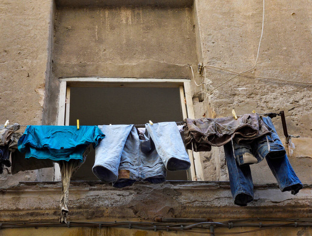 A low angle shot of drying laundry hanging outside an old building - Фото, зображення