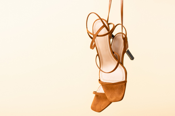 brown suede heeled sandals isolated on beige - 写真・画像