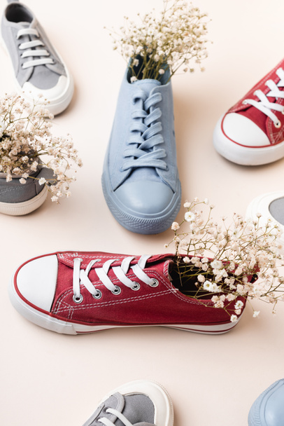 casual sneakers and wildflowers on white background - Foto, Imagem