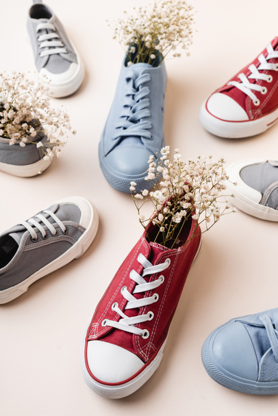 casual sneakers and wildflowers on white background - Foto, Bild