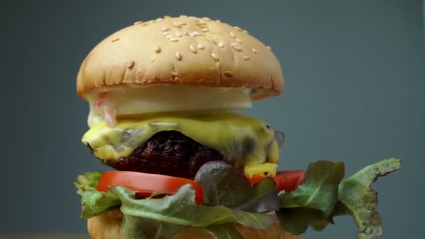 hamburguesa casera sabrosa fresca con verduras frescas, lechuga, tomate, queso en una tabla de cortar. Espacio libre para texto - Imágenes, Vídeo