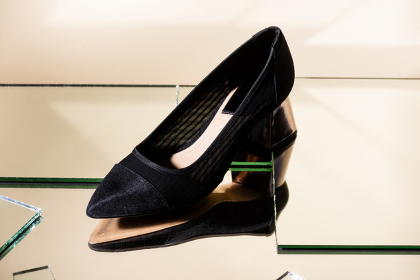 elegant black heeled shoe on mirror surface - 写真・画像