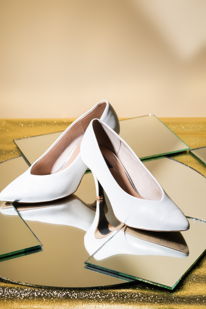 elegant white heeled shoes on mirror surface - Fotó, kép