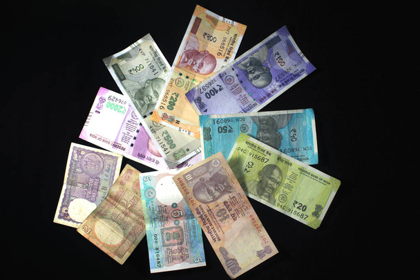 Most és a régi indiai valuták. 50, 100, 200, 500 rúpiás bankjegyek és érmék. Indiai valuta elszigetelt fekete háttér. - Fotó, kép