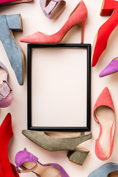 top view of heeled shoes and empty frame on white background - Fotó, kép