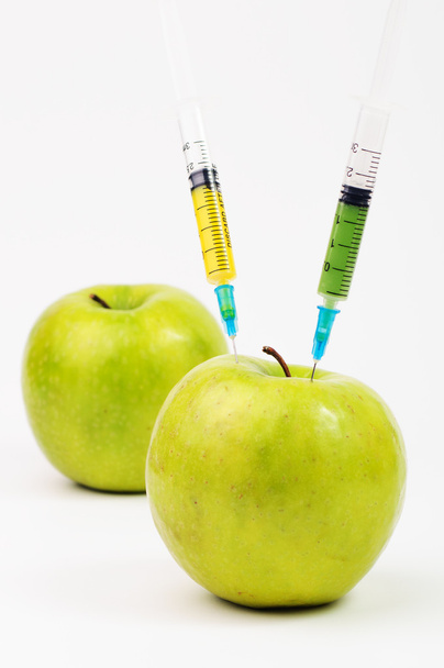 Tre mele con siringhe iniettando liquido colorato
 - Foto, immagini