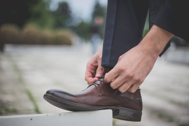 A groom putting on his shoes for the wedding ceremony - Photo, Image