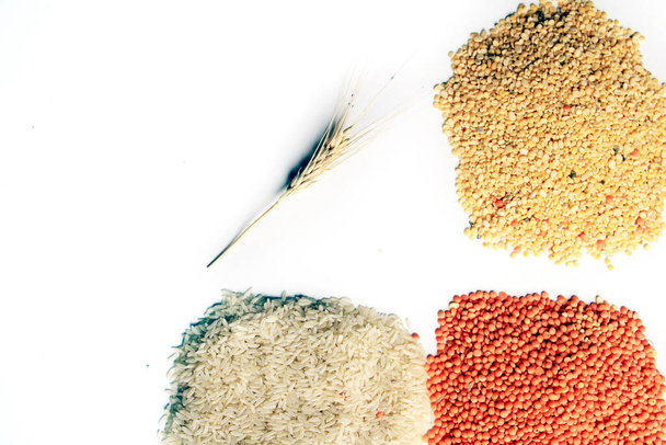 Куча сырого рисового зерна, красная чечевица и голубиный горох. Рисовые зерна, бобы и красная чечевица изолированы на белом фоне. Сухое питание. - Фото, изображение