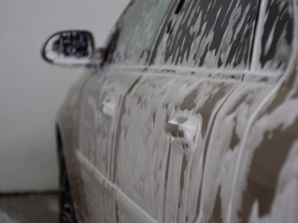 machine in the foam from car shampoo. self-service car wash. dripping foam. - Photo, image