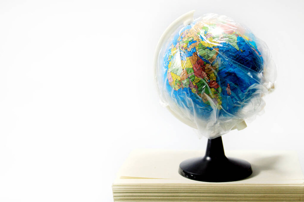 Dramatic atmosphere with plastic paper on the globe coronavirus has spread around the world. World globe in isolation under plastic cover. - Zdjęcie, obraz