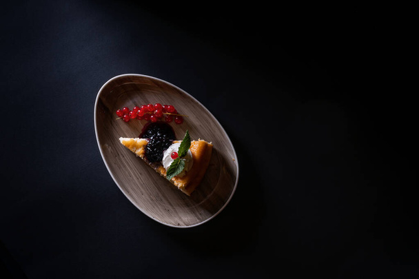 A top view of cheesecake with berries isolated on dark background - Fotoğraf, Görsel