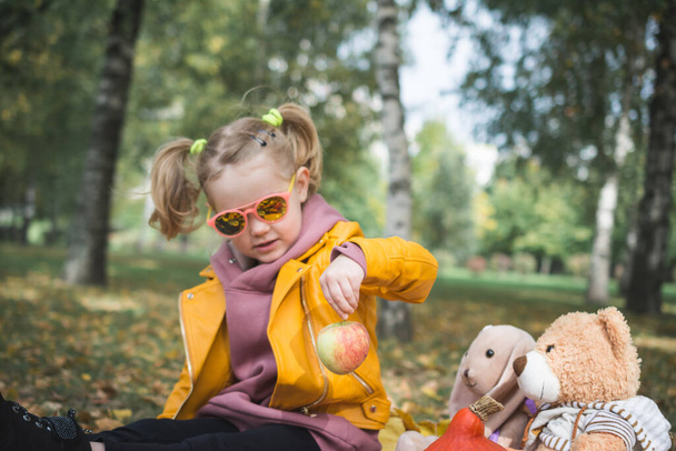 three year old cheerful girl child playing on picnic in autumn park - Foto, Imagem
