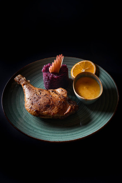 A vertical shot of a turkey leg with sauce isolated on black background - Foto, afbeelding
