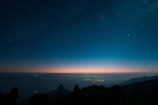 A beautiful starry night over mountains, water and trees in Kodanad, India - Photo, Image