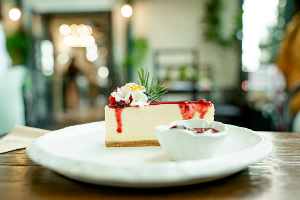 Photo en gros plan de délicieux gâteaux sur des assiettes en céramique joliment décorées et un fond bokeh. - Photo, image