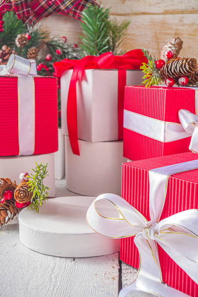 С Рождеством и Новым годом. Фон поздравительных открыток Ноэля. Рождественские подарочные коробки с праздничными лентами, на модных белых подиумах, с пространством для вашего продукта, деревянный фон - Фото, изображение