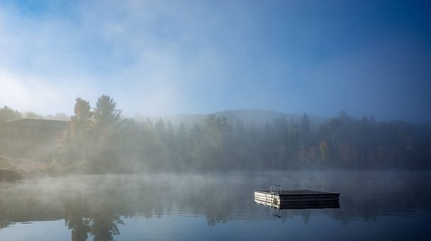 Вид на шлюпку, пришвартованную в Лак-Суперюре, туманное утро с туманом, в Лорентиде, Мон-Трефлан, Квебек, Канада - Фото, изображение