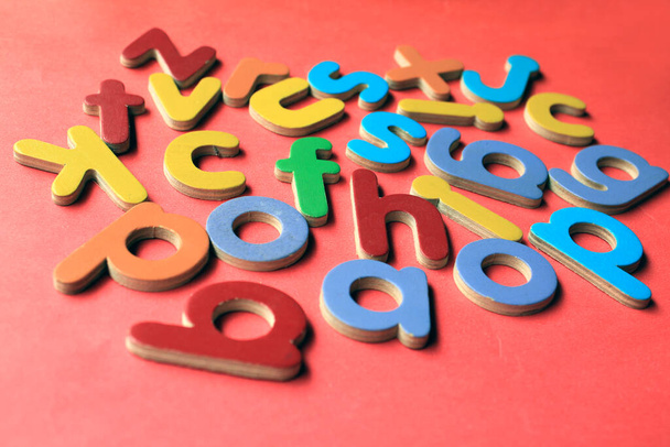 Kleurrijke houten Engelse kleine letters op een roze achtergrond. - Foto, afbeelding