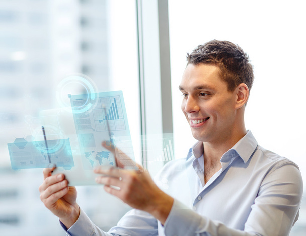 Smiling businessman with tablet pc in office - Photo, image