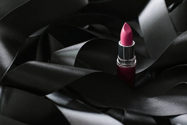 ブラックシルクの背景にピンクの口紅、豪華な化粧品と美しさの化粧品 - 写真・画像