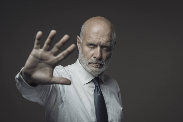 Business executive showing his hand and making a stop gesture - 写真・画像
