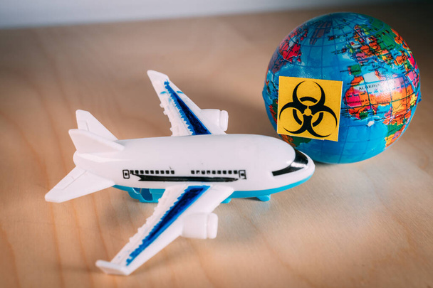 Toy plane next to a globe with the biohazard symbol - Photo, Image
