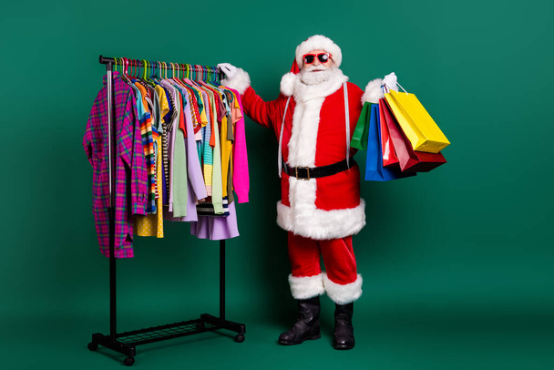 Full length body size view of his he nice fat fat cheerful Santa father buyer visit outlet center bargain carrying buyings things choose choice season garment isolated over green color background - Zdjęcie, obraz