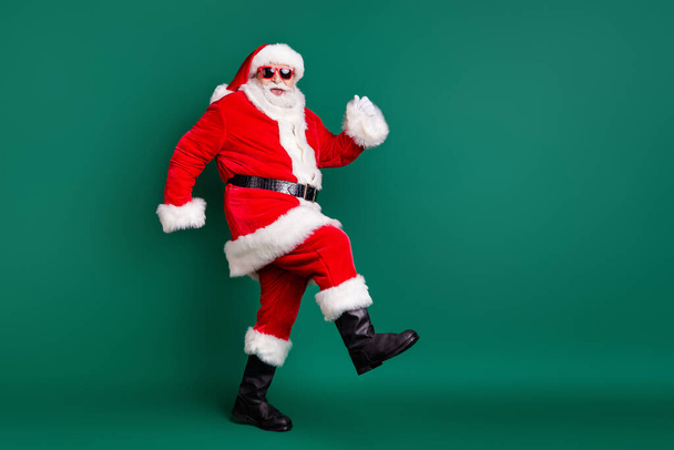 Full body size profile photo of retired grandpa funny walk together elves deer buy present gift kids wear red santa costume coat gloves sunglass cap isolated green color background - 写真・画像