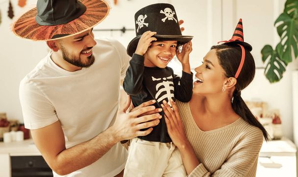 счастливая многонациональная семья мать, отец и маленький сын веселятся и празднуют Хэллоуин в хоме - Фото, изображение