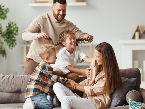щаслива сім'я мати батько і діти розважаються вдома на дивані
 - Фото, зображення