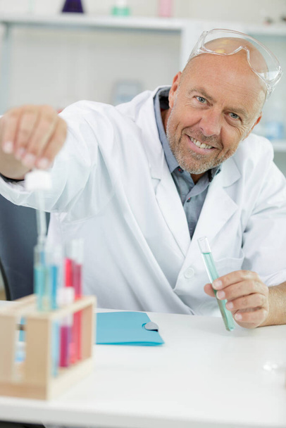 happy man holding a test-tube at the laboratory - Φωτογραφία, εικόνα