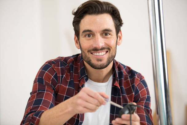 happy man is fixing a furniture at home - Foto, Bild