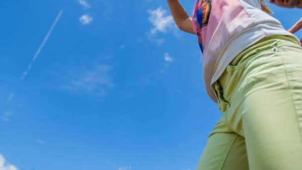 Ein junges Mädchen hält Luftballons in die Höhe, und alle schauen in die Luft. Es ist ein schöner Sommertag und der Himmel ist blau. - Filmmaterial, Video
