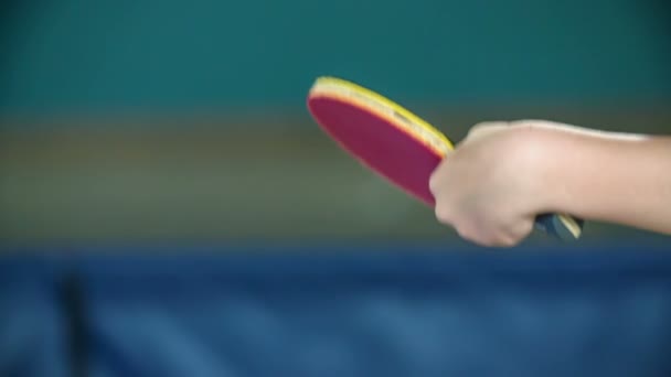 Красная весло бьет желтый шар для пинг-понга. Дети играют в настольный теннис в школьном спортзале. - Кадры, видео