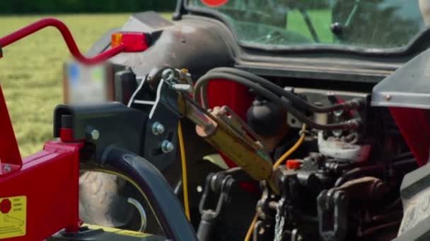 Een boer drukt op een knop in zijn tractor en de draden en de connector bewegen.. - Video