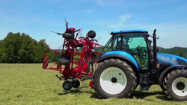A gép egyik oldala lassan kinyílik. Egy kék traktor áll egy nagy füves mező közepén.. - Felvétel, videó